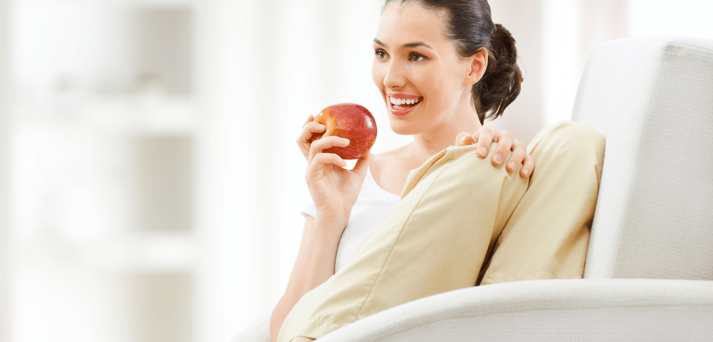 Mujer sonriente con una manzana, símbolo de salud digestiva